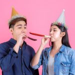 Portrait cheerful young couple with party prop